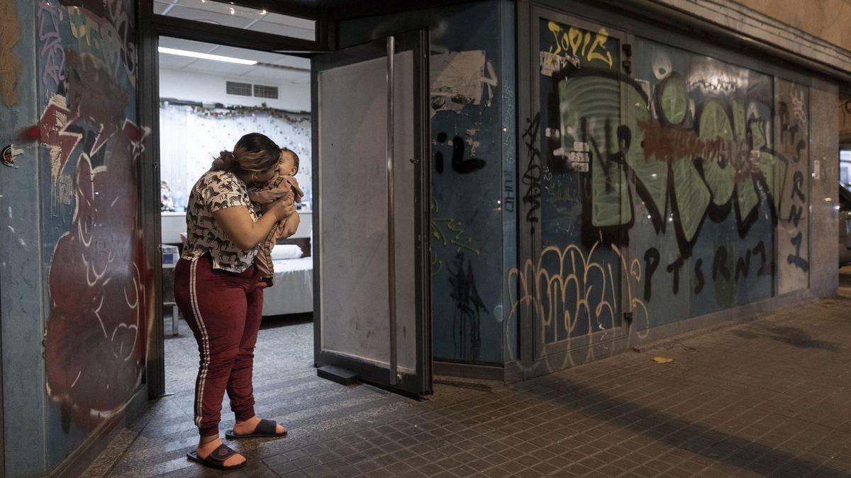 Diamata Gheorghe arropa a su hija Raisa, en la antigua oficina de un banco ocupada donde vive con el resto de su familia.