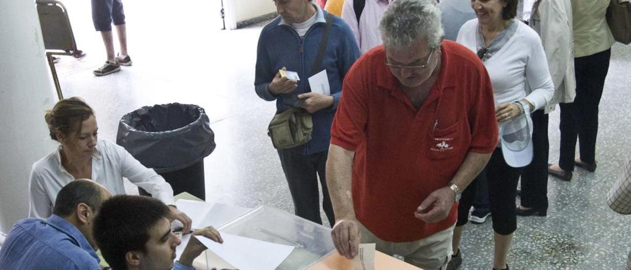 Un votante deposita su papeleta en la urna, imagen de archivo.