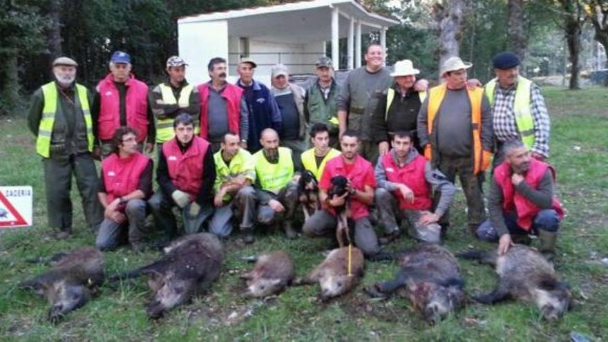 Los 19 cazadores de las cuadrillas de A Caldesiña y O Xarro que abatieron el domingo seis jabalíes en Moreira, con sus capturas.