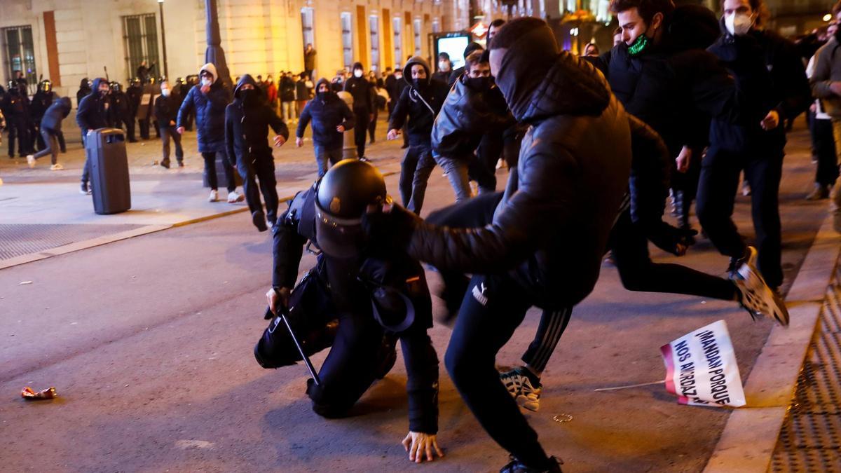 Dos manifestantes agreden a un policía en Madrid en las protestas por Pablo Hasél.