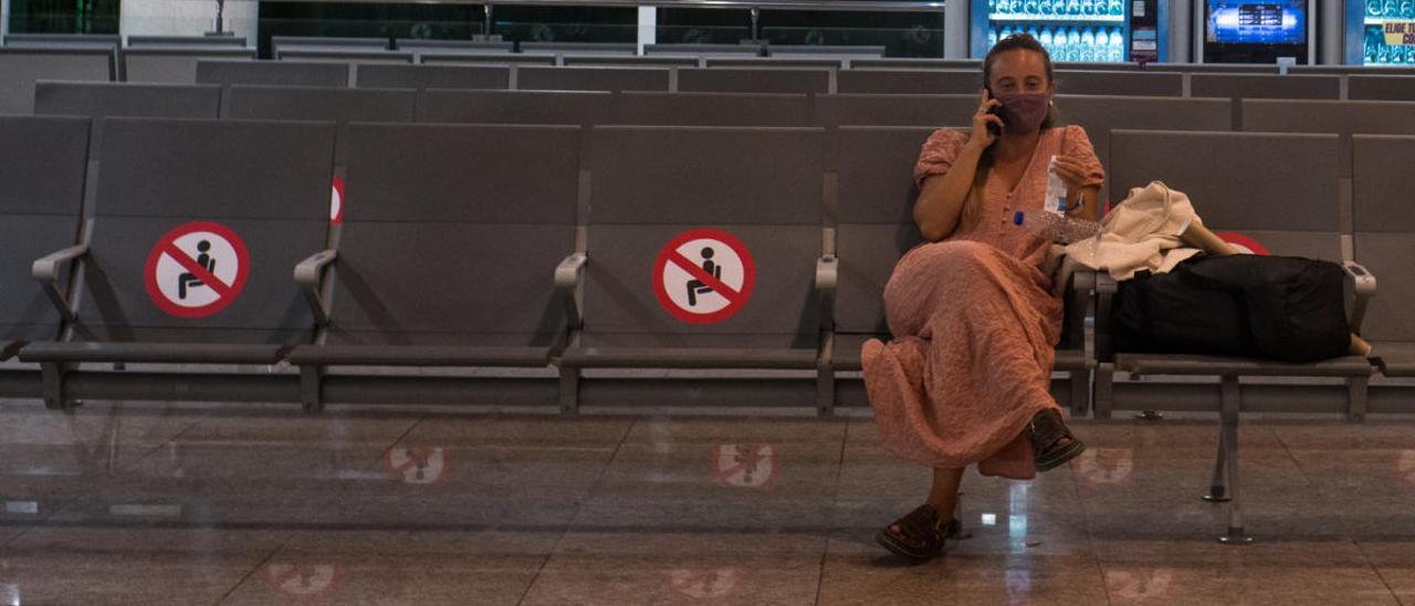 Una mujer habla por teléfono en el aeropuerto de El Prat.