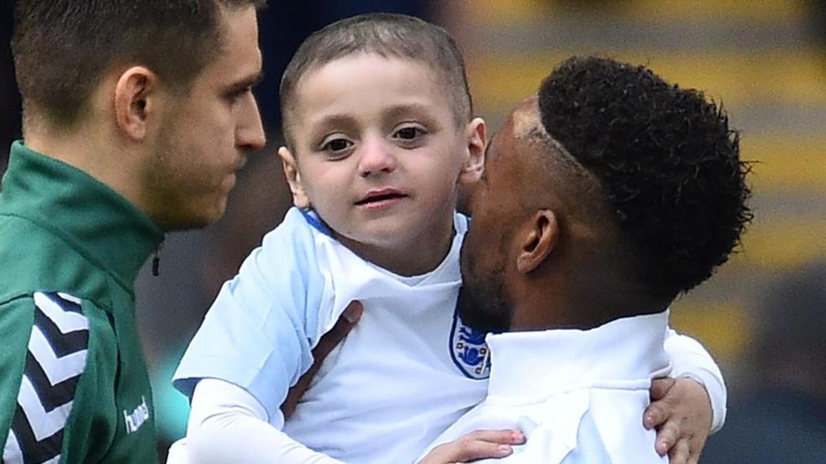 Defoe sostiene en brazos a Bradley, el niño aquejado de un cáncer terminal