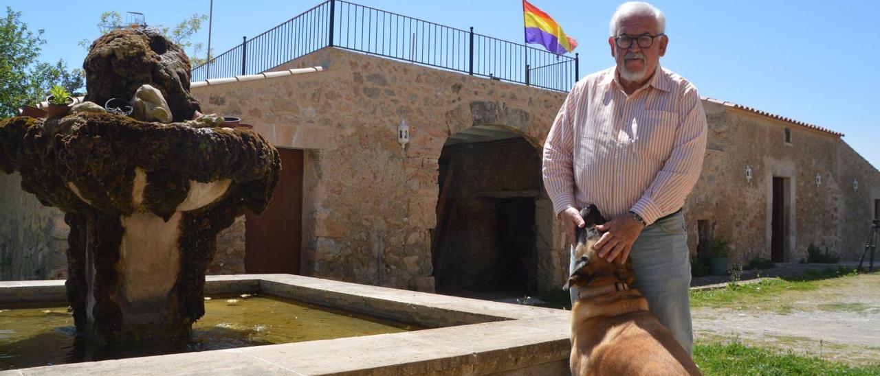 Joan Manuel López Nadal posa con su perro ‘Truc’ en su refugio de Son Servera, presidido por una bandera republicana. | BIEL CAPÓ