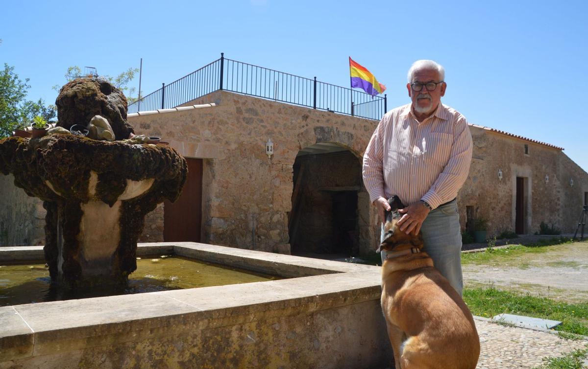 Joan Manuel López Nadal posa con su perro ‘Truc’ en su refugio de Son Servera, presidido por una bandera republicana. | BIEL CAPÓ