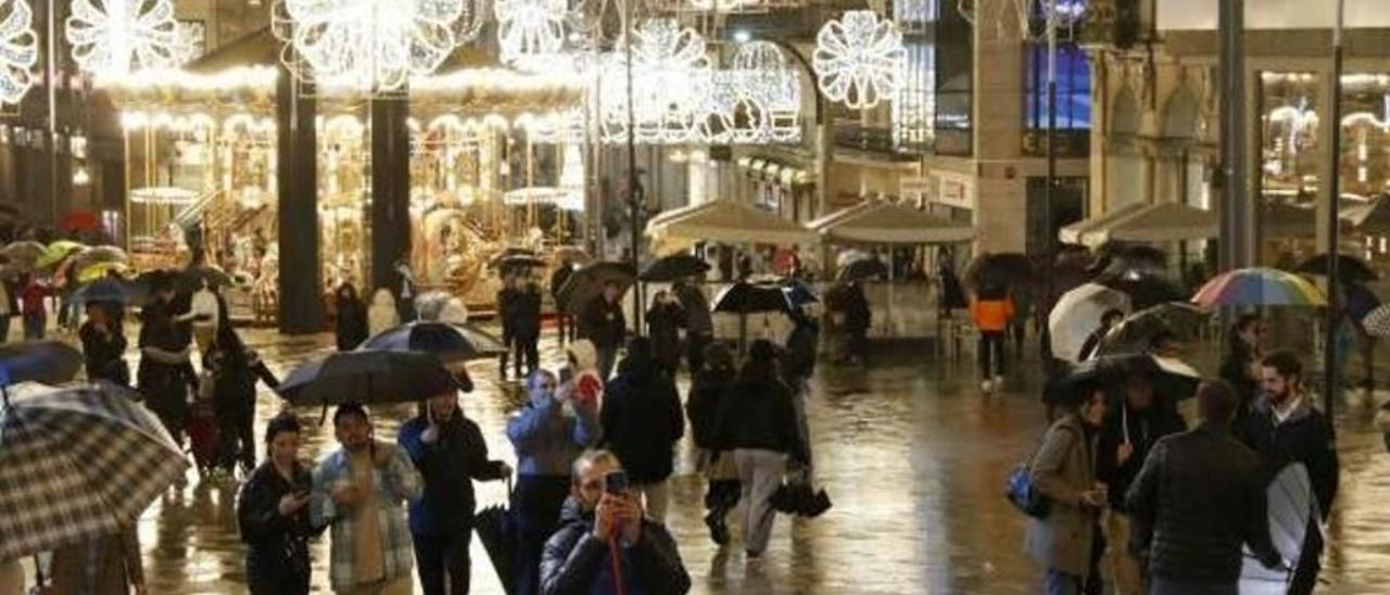 Varias personas fotografían el árbol gigante de Porta do Sol, uno de los puntos clave de la Navidad de Vigo. JOSÉ LORES