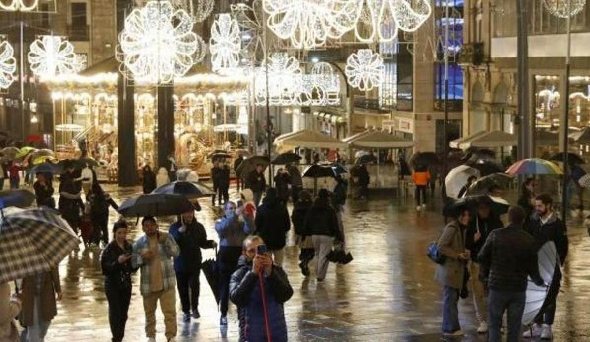 Varias personas fotografían el árbol gigante de Porta do Sol, uno de los puntos clave de la Navidad de Vigo. JOSÉ LORES