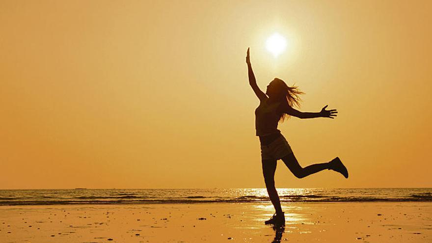 Una mujer hace ejercicio en una playa.