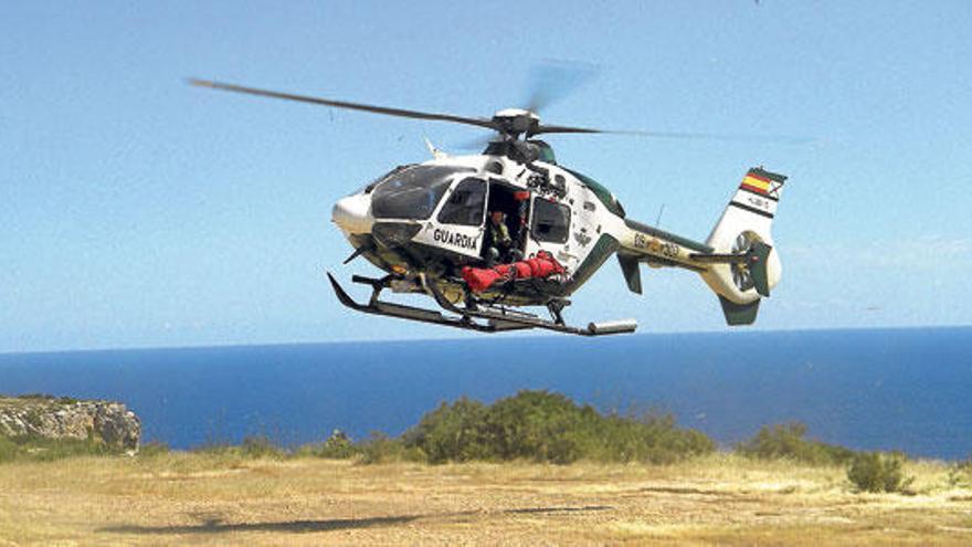 El helicóptero de la Guardia Civil transporta la camilla con el cuerpo del piragüista fallecido.