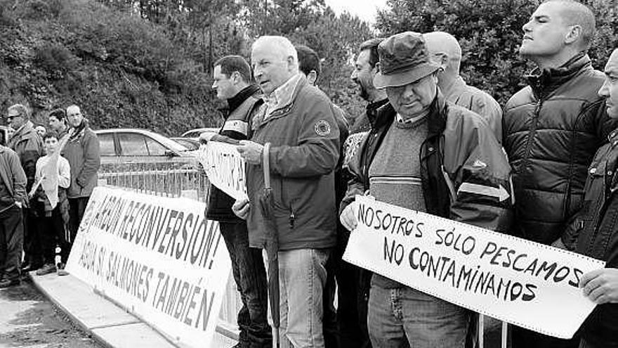 Algunos de los pescadores, ayer, en el embalse de Arbón, con pancartas de protesta.