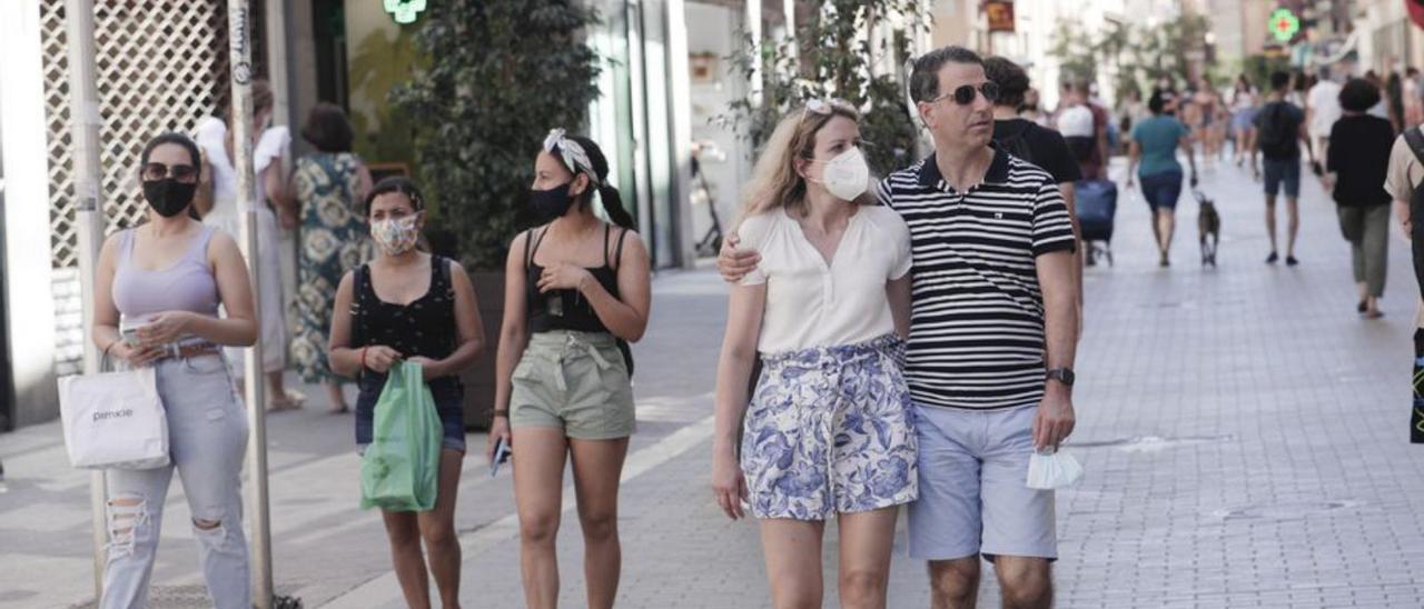 Varias personas utilizan mascarilla para pasear por Palma.