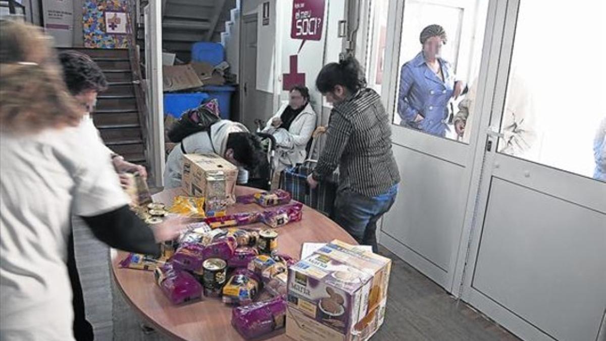 Reparto de alimentos a personas en situación de necesidad en un local de la Creu Roja de L'Hospitalet, en marzo del 2012.
