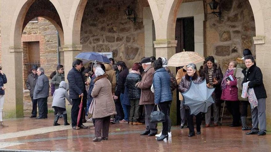 Vecinos del municipio se resguardaban ayer de la lluvia en la iglesia de La Asunción a la salida de misa.