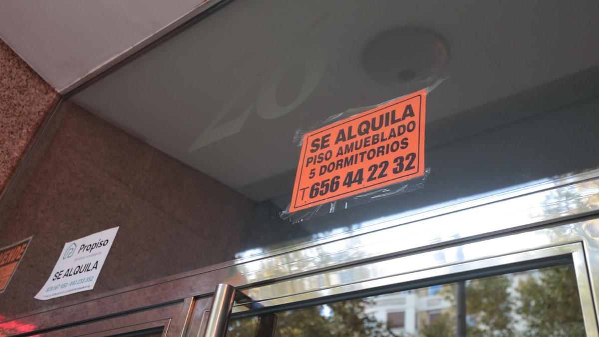 Dos carteles de alquiler en un portal de un bloque de pisos de Zaragoza.
