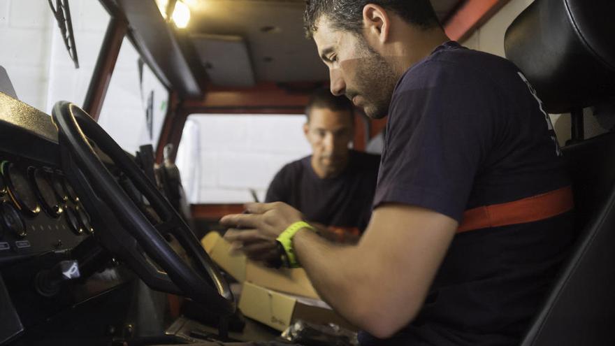 Los exbomberos Eduardo Martínez (primer plano) y Pedro Rodríguez en un vehículo en el parque.