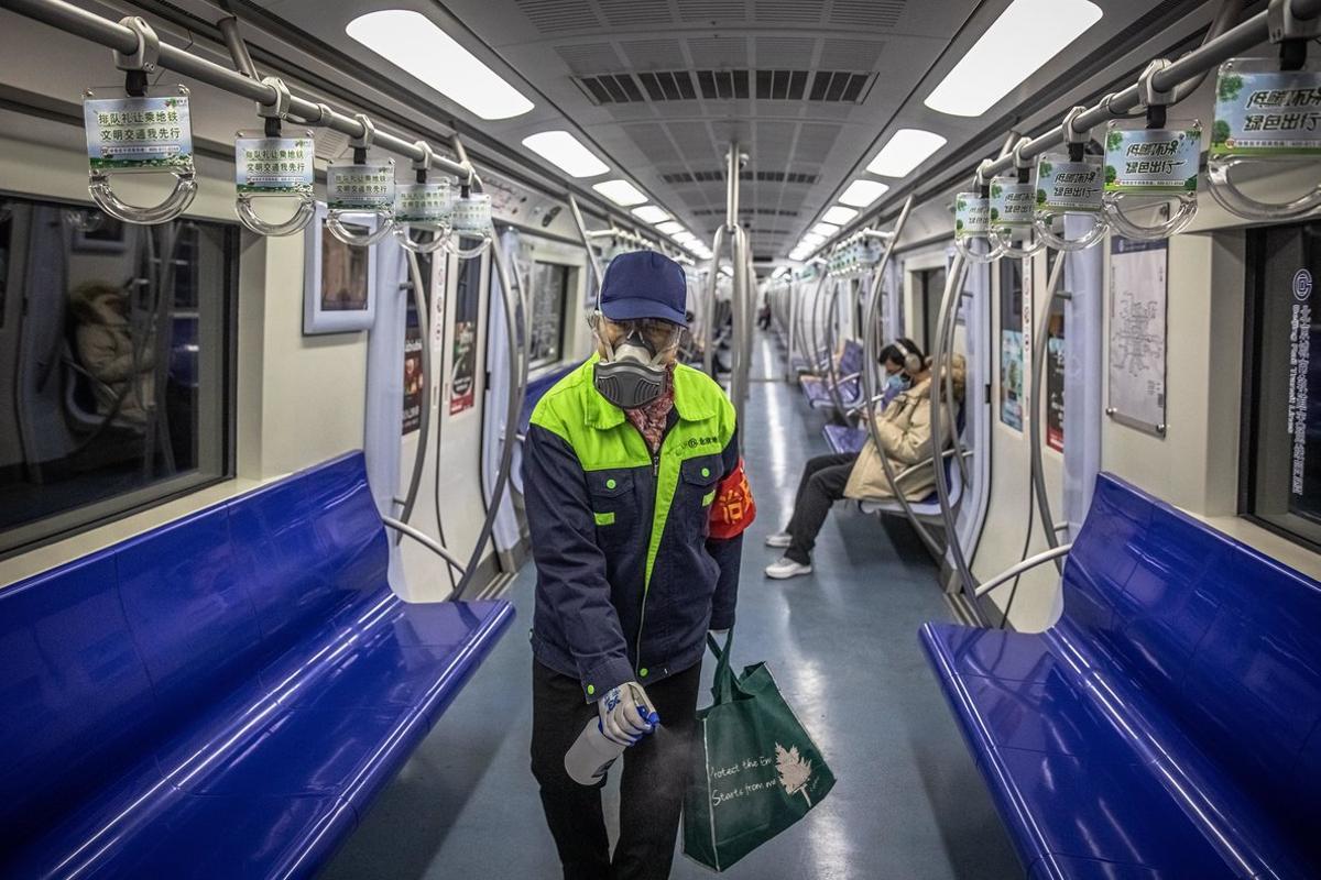 -FOTODELDIA- PIL01. PEKÍN (CHINA), 10/02/2020.- Un trabajador del metro de Pekín protegido con mascarilla desinfecta un vagón del metro este lunes, en Pekín, China. Cientos de miles de trabajadores chinos regresaron hoy a cuentagotas a oficinas y fábricas tras las prorrogadas vacaciones del Año Nuevo Lunar mientras el país sigue luchando contra el nuevo coronavirus, que deja ya al menos 908 muertos en China, entre la insuficiencia de suministros para paliar el brote, y más de 40.00 contagiados. EFE/Roman Pilipey