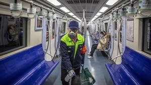 -FOTODELDIA- PIL01. PEKÍN (CHINA), 10/02/2020.- Un trabajador del metro de Pekín protegido con mascarilla desinfecta un vagón del metro este lunes, en Pekín, China. Cientos de miles de trabajadores chinos regresaron hoy a cuentagotas a oficinas y fábricas tras las prorrogadas vacaciones del Año Nuevo Lunar mientras el país sigue luchando contra el nuevo coronavirus, que deja ya al menos 908 muertos en China, entre la insuficiencia de suministros para paliar el brote, y más de 40.00 contagiados. EFE/Roman Pilipey