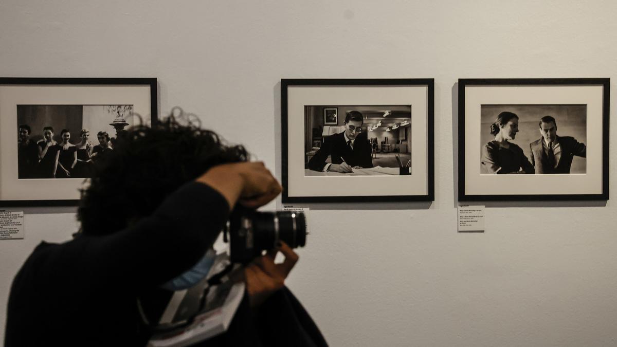 Archivo - Una persona fotografía imágenes de una muestra dedicada a las fotógrafas Eve Arnold, Inge Morath y Cristina García Rodero, de la Agencia Magnum Photos