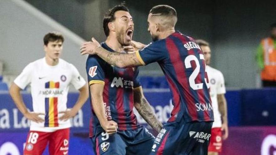Sergi Enrich y Sielva celebran el gol del empate del Huesca en la recta final del partido.