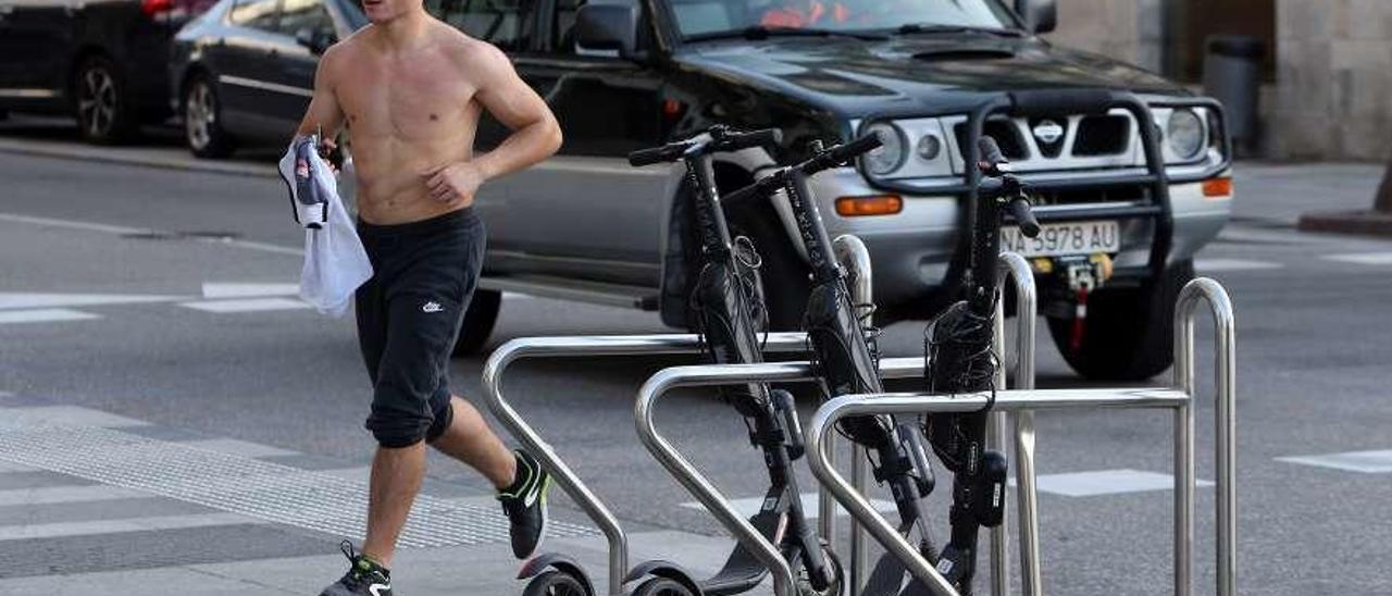 Patinetes eléctricos de la empresa Buny sujetos a &quot;aparbicis&quot; públicos de la ciudad. // Marta G. Brea