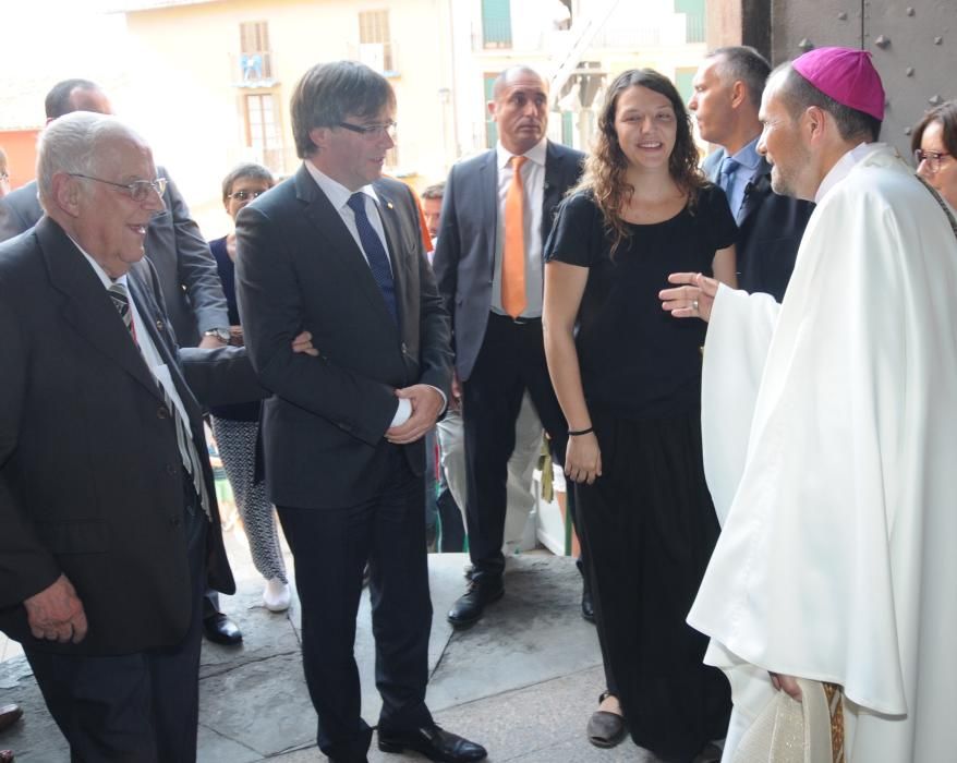 El bisbe de Solsona rep al cancell de l'església al president Generalitat en preséncia alcaldessa de Berga (CUP) que l'ha acompanyat i després se n'ha anat sense participar de l'ofici religiós.