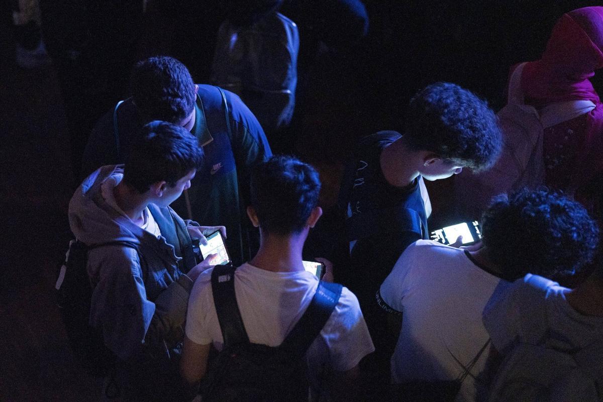 Grupo de jóvenes mirando su teléfono móvil.