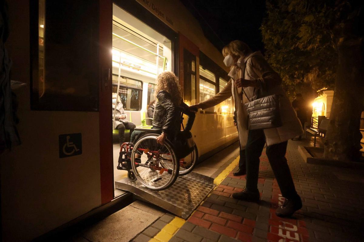 Una mujer sube al metro en silla de ruedas tras la colocación de la rampa habilitadora.