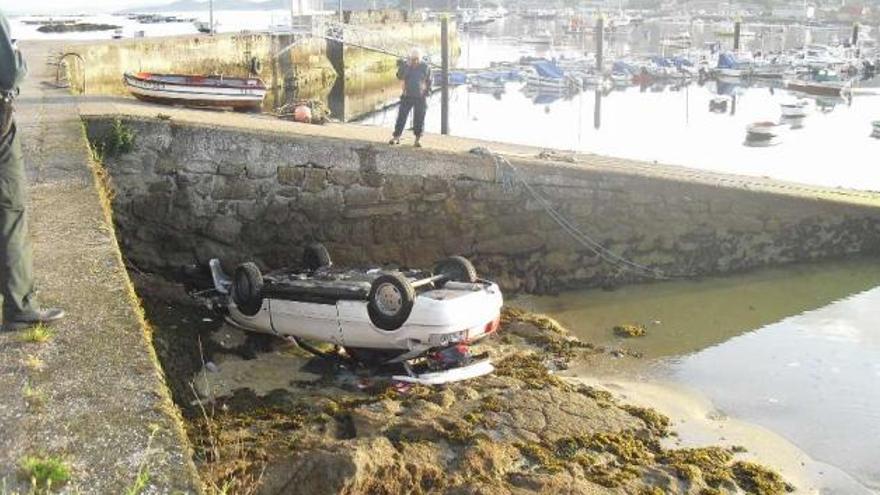 Salen por su pie de su coche tras caer a un muelle en Cangas