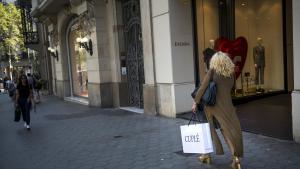 Una mujer camina con sus compras en el paseo de Gràcia