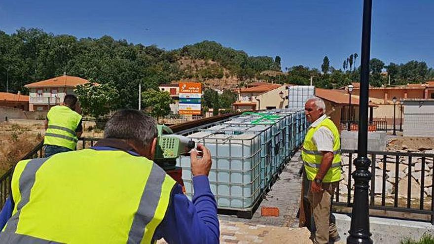 Los técnicos realizan las comprobaciones con la carga de los bidones que en su capacidad máxima contienen 26.000 litros de agua.