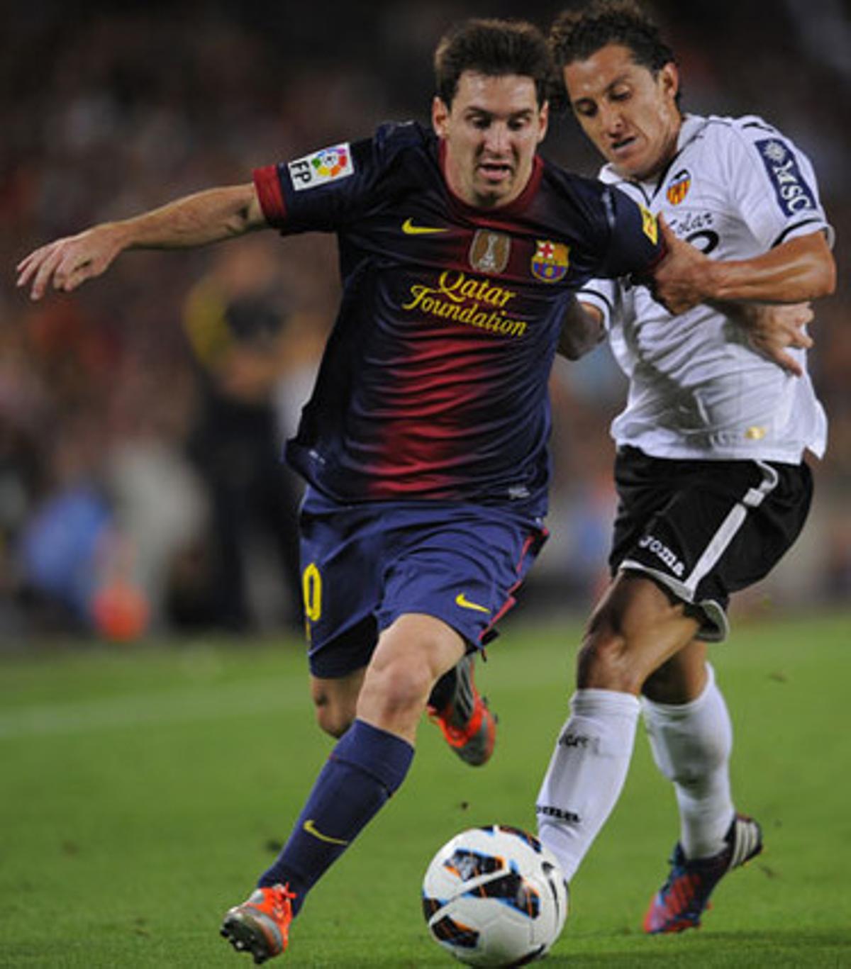 Leo Messi intenta desfer-se del seu oponent Jonas del València, en un partit de Lliga al Camp Nou. Any 2012.