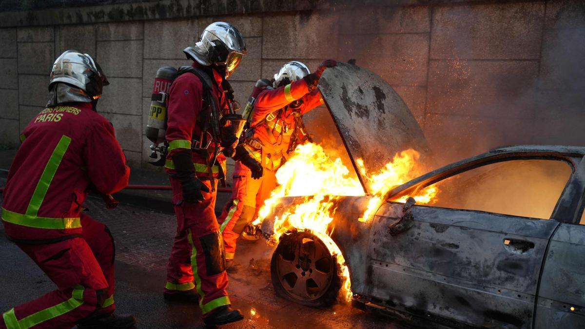 Bomberos apagando un fuego en un vehículo en Nanterre.