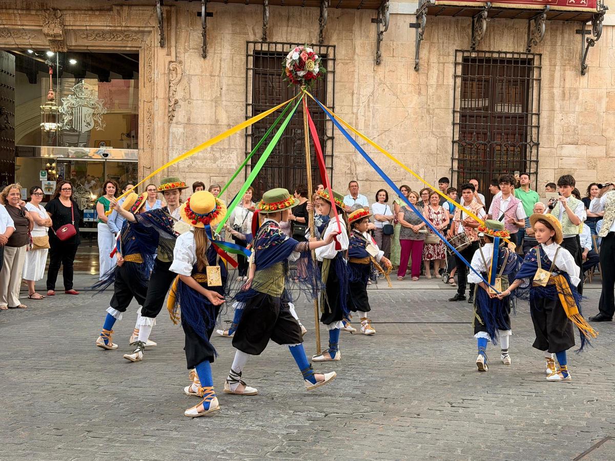 Niños danzantes tejen y destejen alrededor del palo central