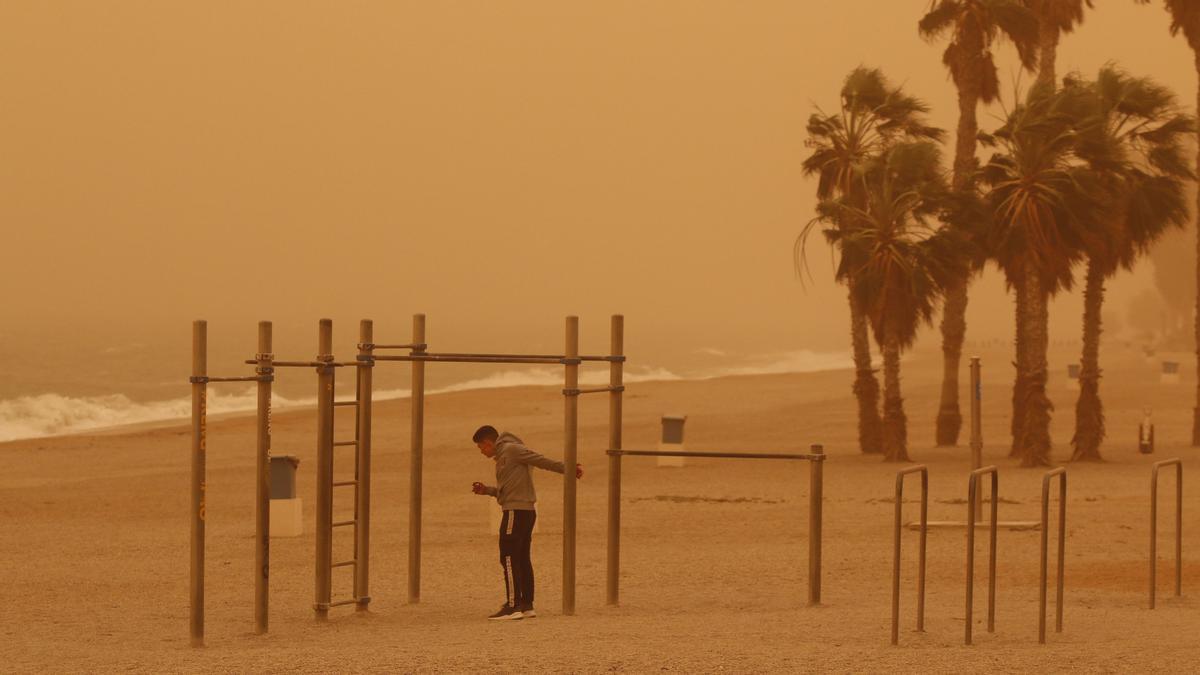 ROQUETAS DE MAR (ALMERÍA), 15/03/2022.- Un joven hace deporte en la playa de Aguadulce, Roquetas de Mar ( Almería) bajo la intensa calima debido al polvo procedente del desierto del Sáhara ha penetrado en la Península y Baleares, y ha teñido de rojo los cielos de la costa mediterránea, en Andalucía especialmente en Jaén y Almería, donde este fenómeno no se registraba con esta intensidad desde hacía varias décadas. EFE/Carlos Barba