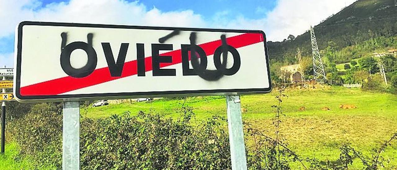 Un cartel indicador sobre el que aparece escrito con espray Uviéu.