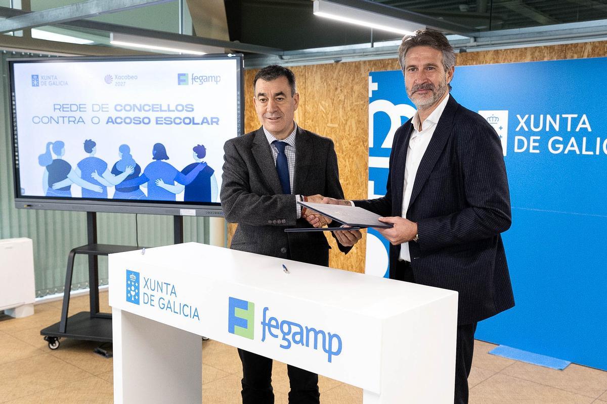 El conselleiro de Educación, Román Rodríguez y el presidente de la Fegamp, Alberto Varela, tras la firma.