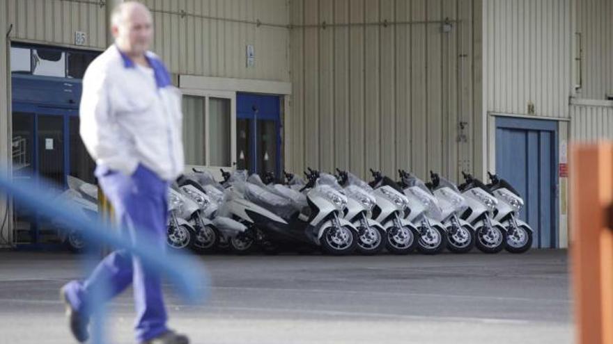 Un trabajador pasa ante un grupo de motocicletas en la factoría de Suzuki.