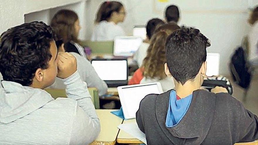 Un grupo de alumnos atiende a una clase donde cuentan con tabletas para coger apuntes y buscar información.