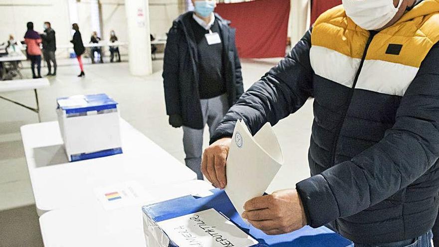 Romanesos votant amb mascareta ahir al Palau Firal