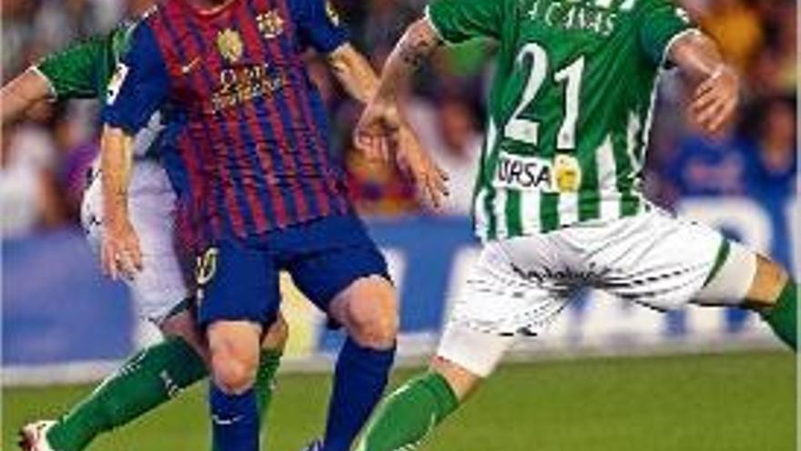 Leo Messi intenta marxar de la pressió de dos jugadors del Betis.