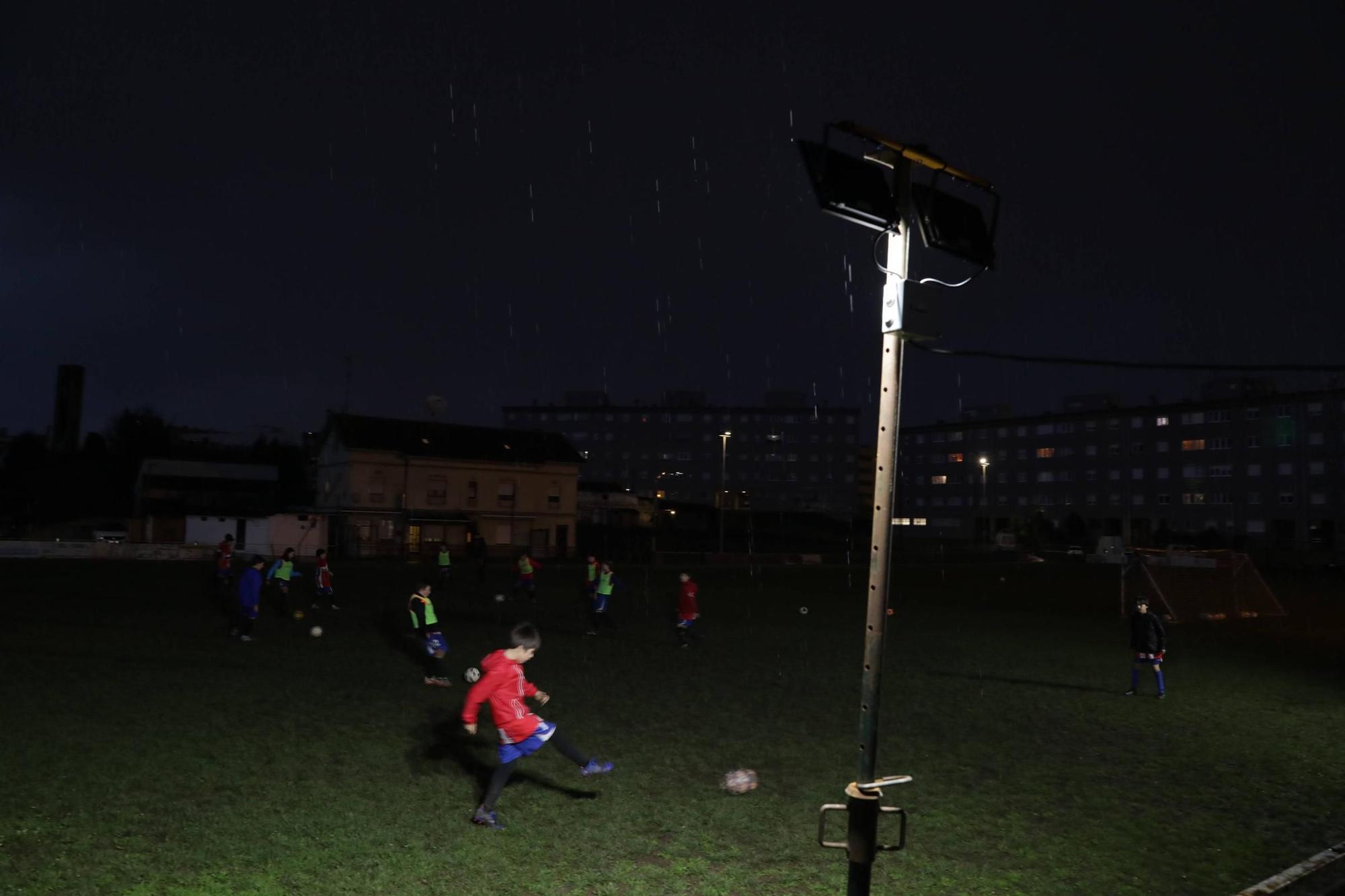 Condenados a jugar al fútbol casi a oscuras en Gijón (en imágenes)