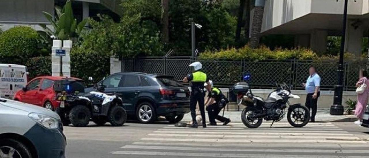 Dos policías locales de Marbella flanquean el cuerpo de la víctima.