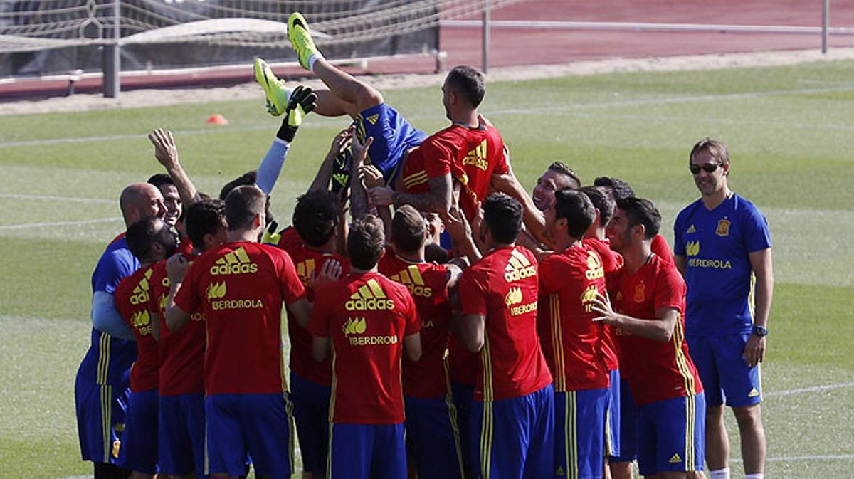 Los compañeros de la selección española mantean al delantero Paco Alcácer a modo de bienvenida, durante el entrenamiento del grupo.