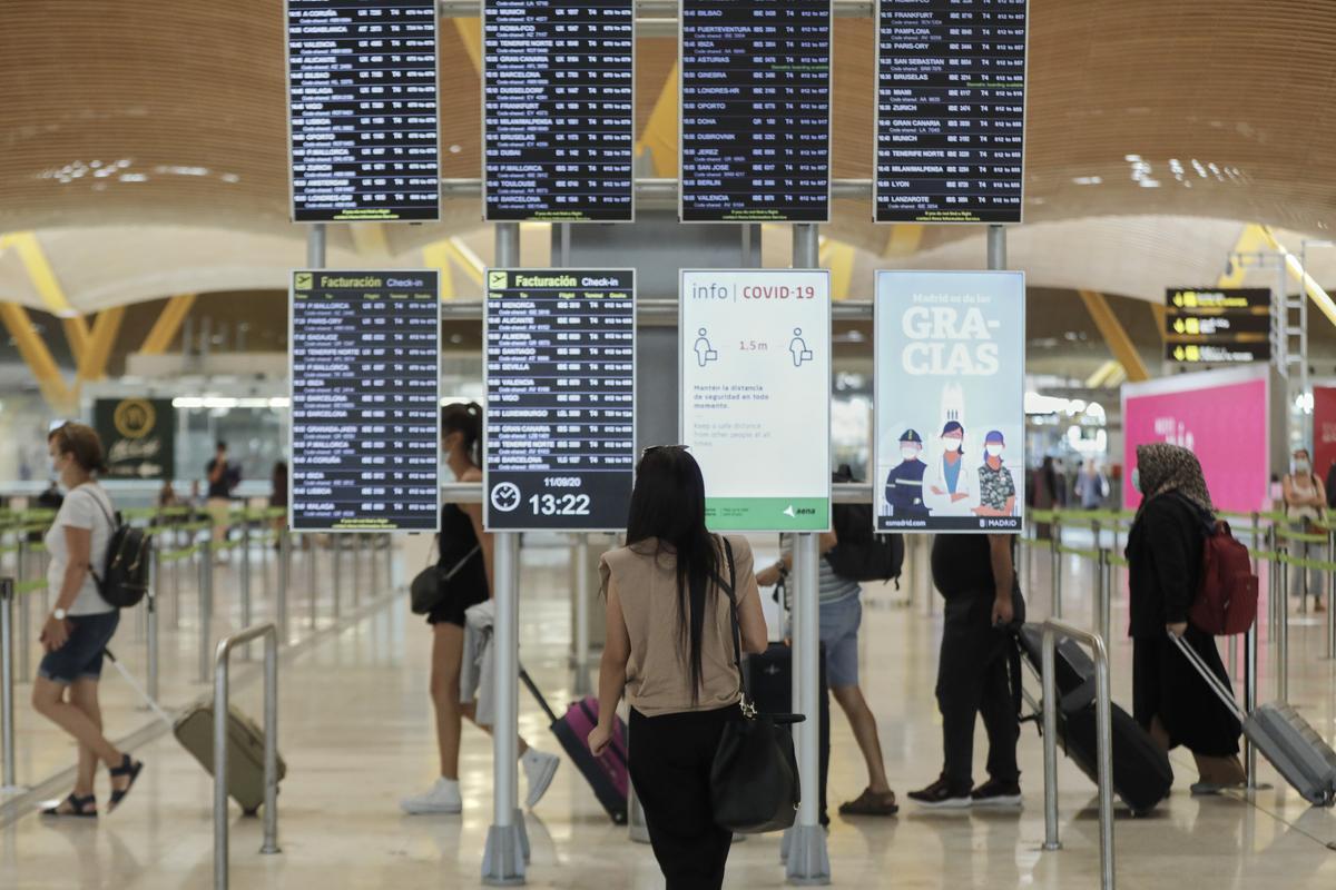 Archivo - Pasajeros cerca de páneles informativos en la terminal T4 del aeropuerto Adolfo Suárez Madrid-Barajas, en Madrid (España), a 11 de septiembre de 2020.