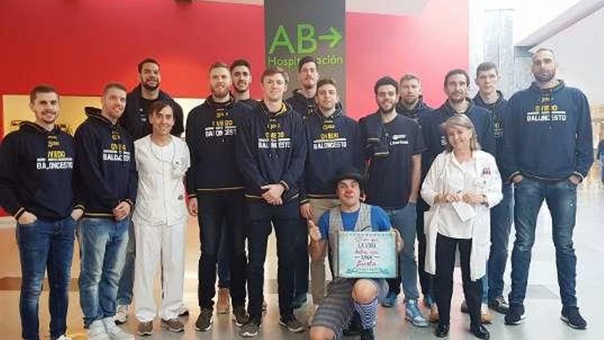 La plantilla del Liberbank Oviedo, con médicos y con el payaso Jowini, ayer en el HUCA.