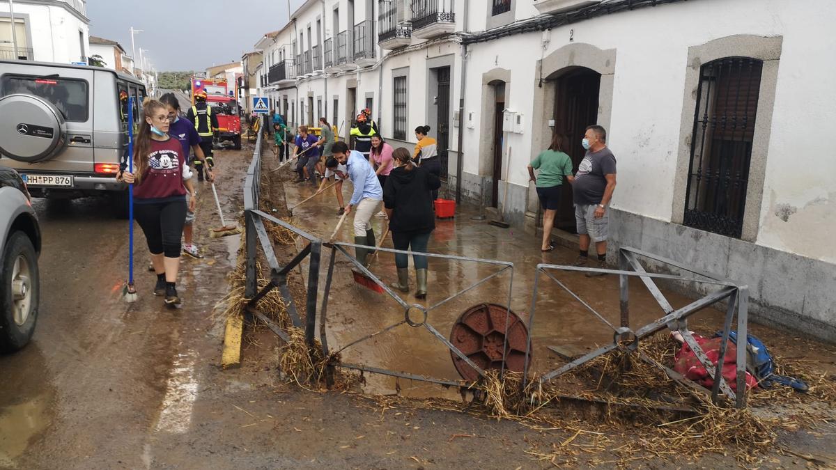 Los vecinos de Alcaracejos intentan limpiar las calles afectadas por la lluvia.