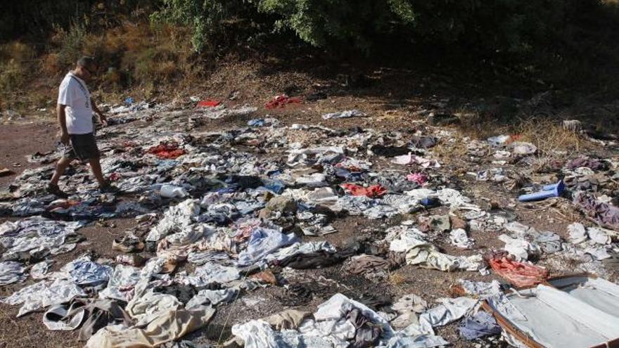 Un vecino pasea por un mar de ropa tirada en mitad del parque periurbano.