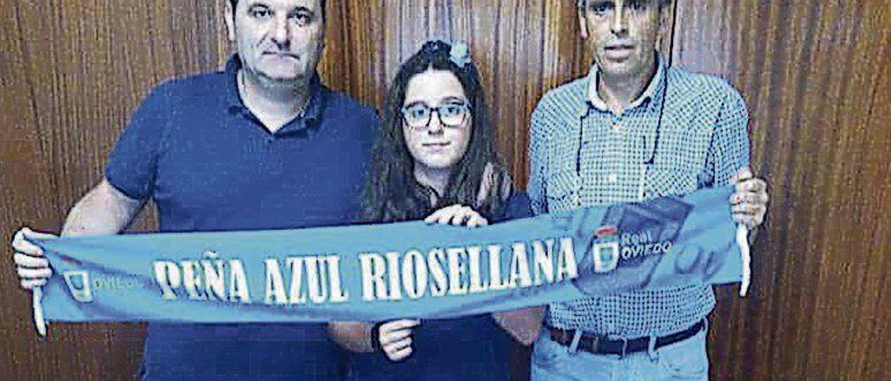 Juan Huergo, Sara Huergo y Roberto Pire muestran la bufanda de la peña azul Riosellana que será enviada a Nepal.