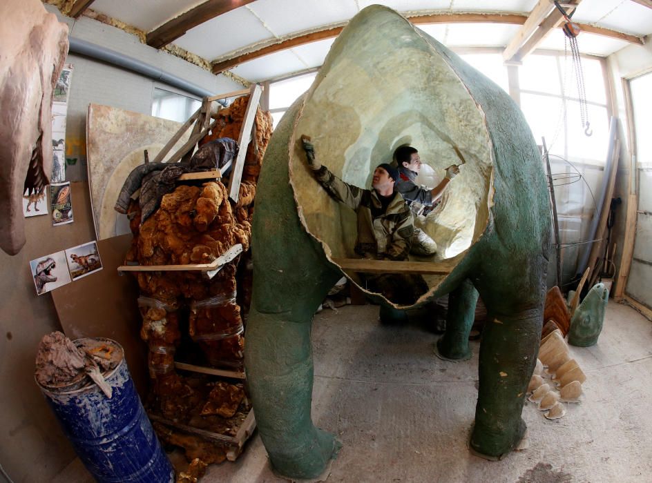 Ayudantes del empresario Vitaly Yan-Vin-Tin trabajan en una escultura de polieturano y fibra de vidriode un dinosaurio en Beryozovka (Rusia).