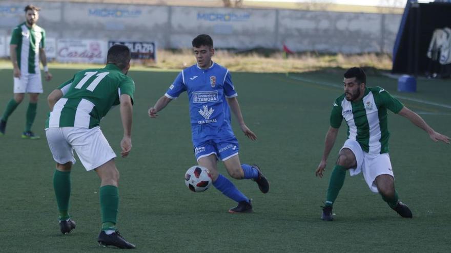 Un jugador del Villaralbo intenta zafarse de dos rivales