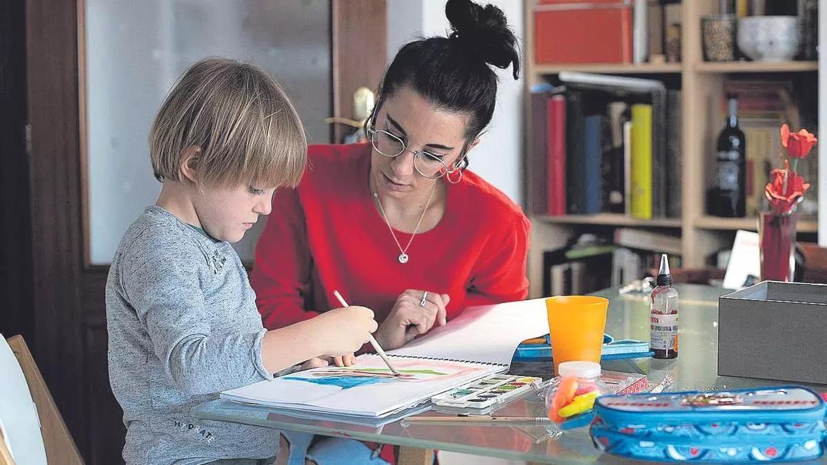 Una madre trabajadora ayuda a su hijo a realizar las tareas escolares.